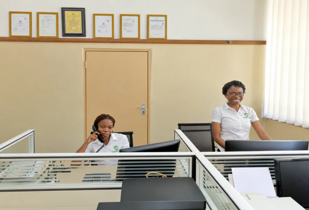 Two Master Transact Limited team members at their office workstations.